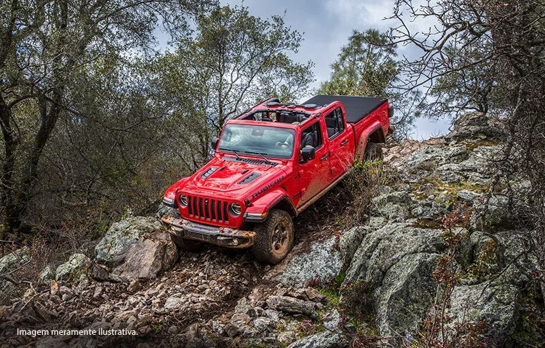 Jeep Gladiator em declive de terreno rochoso acidentado e lamacento.