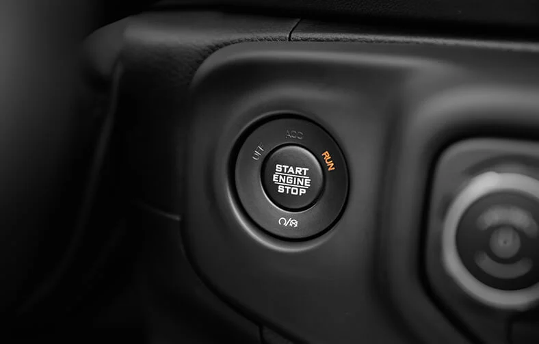 Detalhe atrás do volante do botão de início do Jeep Gladiator sem chave, ao lado da ignição.