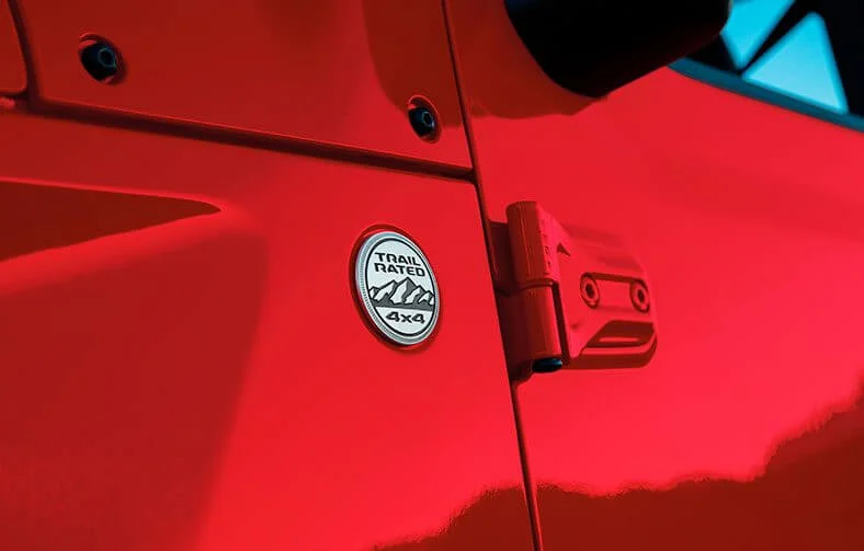 Detalhe do Badge Trail Rated, peça redonda prateada, na lateral do Jeep Gladiator 