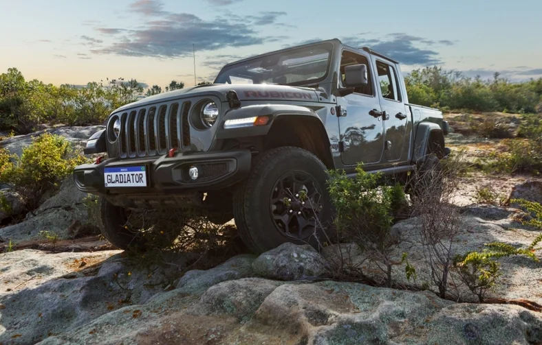 Picape Jeep Gladiator vista frontal e lateralmente em terreno rochoso